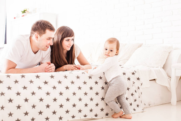 Parents teach the child to climb on the bed - Photo, image