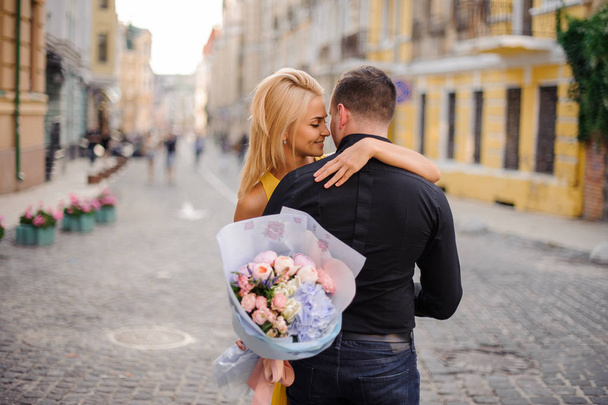 Young and beautiful blonde woman holding a bouquet of flowers an - Photo, image