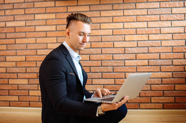 business man using laptop at home while sitting on floor - Photo, image