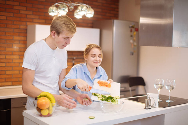 couple cooking together in the kitchen at home - Foto, Bild