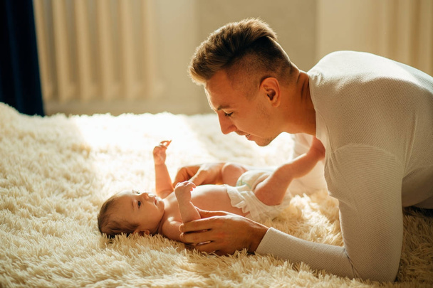 father playing with adorable baby in bedroom - Photo, Image