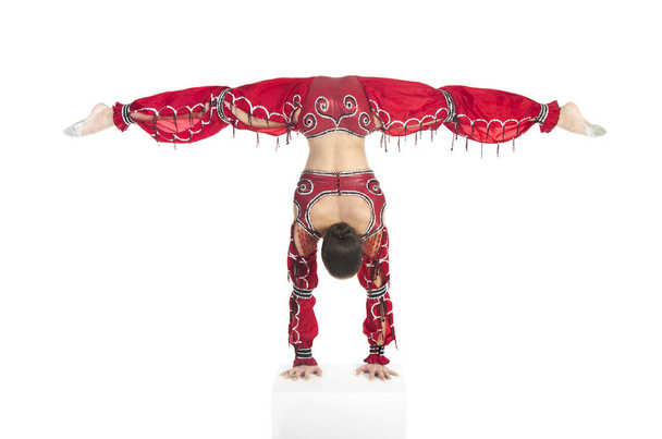 A young contortionist,circus performer in a red suit. - Photo, image
