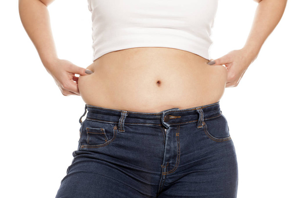 Mujer pellizcando los depósitos de grasa en su cintura
 - Foto, imagen
