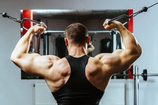 Young adult bodybuilder doing weight lifting in gym - Φωτογραφία, εικόνα