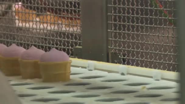 Fábrica de gelados. Linha de transporte de sorvete. Gelado rosa frutado e baunilha em uma xícara de waffle. Fábrica de gelados. Sorvete em um cone
. - Filmagem, Vídeo