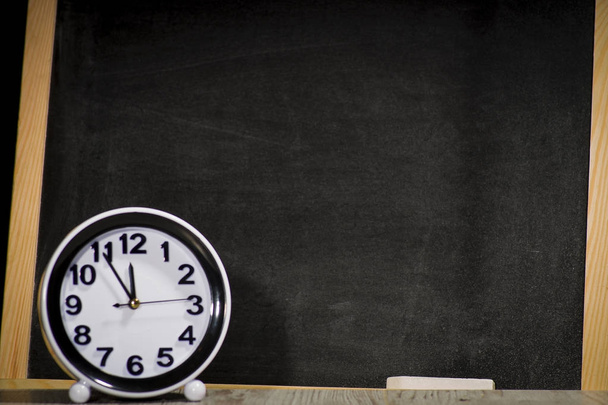     Concept sciences at the school, clock relating to the chalkboard - Фото, изображение