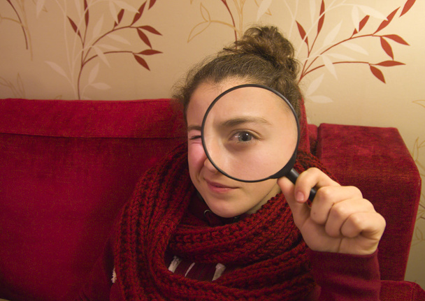 mooie tennager meisje op zoek door een vergrootglas - Foto, afbeelding