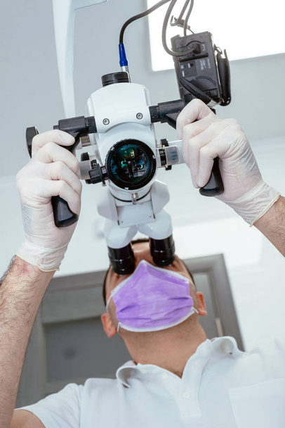 Dentist with a microscope in a dental clinic - Фото, зображення
