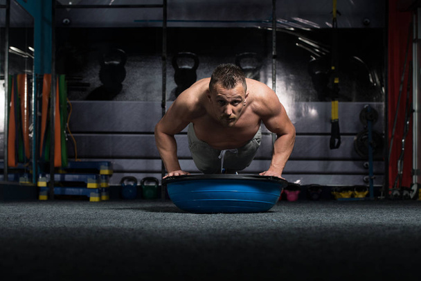 Personal Trainer Doing Pushups On Floor With Bosu Balance Ball As Part Of Bodybuilding Training - Foto, Imagen