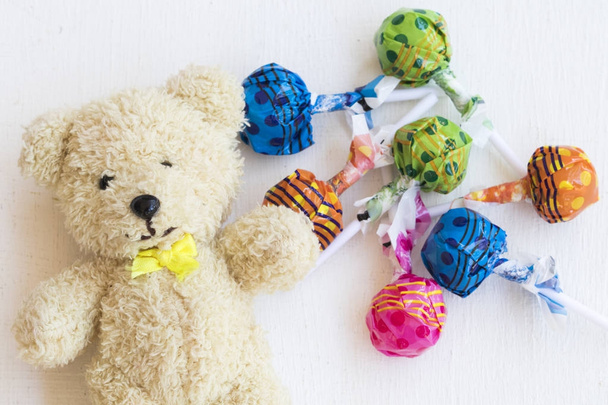 ours en peluche avec bonbons bâton coloré sur fond blanc
 - Photo, image