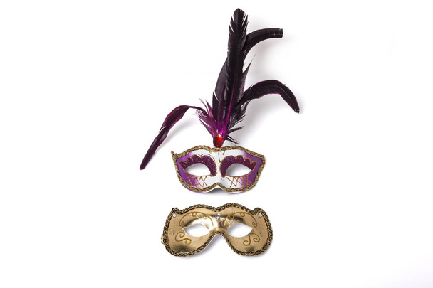 purple venetian mask with feather and Shiny golden masks isolated on white background. - Photo, Image