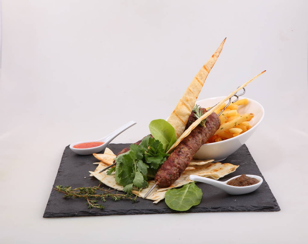 kebab on skewer with potatoes and pita bread (meatball on a skewer served with potato mi sauce) - Photo, Image
