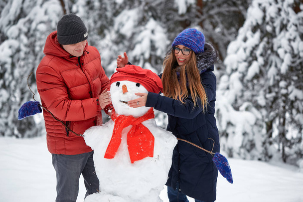 冬の楽しみ。少女と雪玉を作る男. - 写真・画像