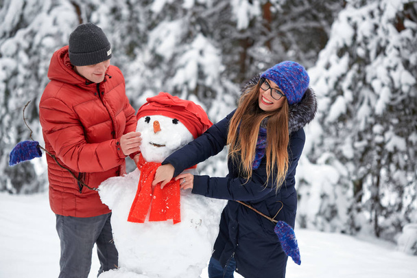 Talvella hauskaa. tyttö ja mies tekemässä lumipalloja
. - Valokuva, kuva