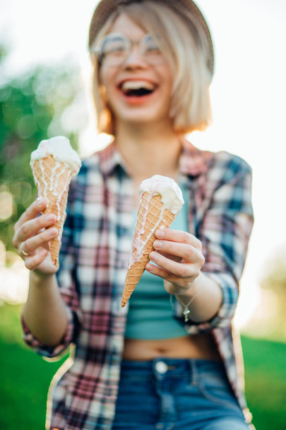 Outdoor closeup fashion portrait of young hipster crazy girl eating ice cream - Foto, imagen