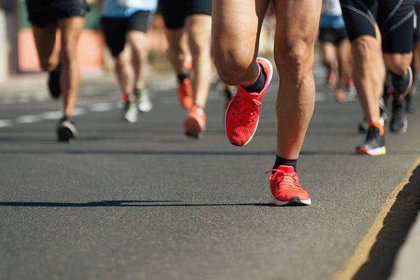 Maratona corsa alla luce della sera, corsa su strada cittadina dettaglio su gambe
 - Foto, immagini