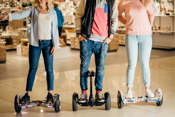 man and two woman riding on Hoverboard in mall - Фото, изображение