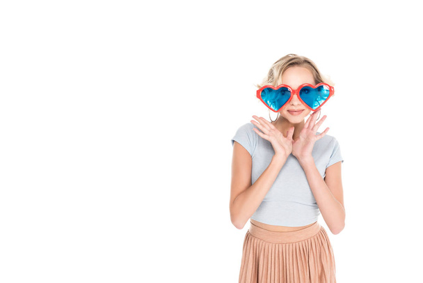 beautiful young woman in big heart shaped sunglasses posing isolated on white - Fotó, kép