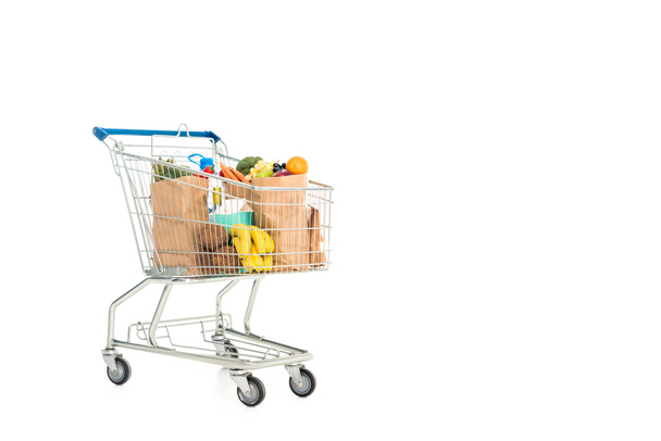 Papiertüten voller Obst und Gemüse in Einkaufswagen isoliert auf weiß - Foto, Bild
