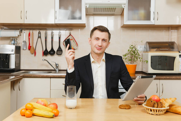 Handsome young business man in suit, shirt, having breakfast, si - Photo, Image