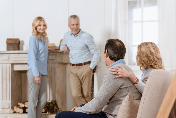Adultos homens e mulheres tendo uma conversa amigável na sala de estar
 - Foto, Imagem