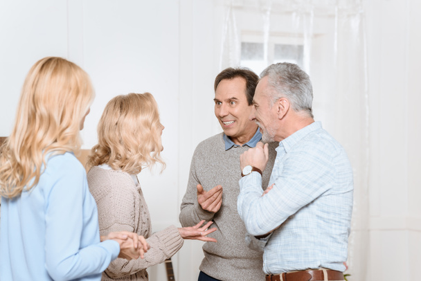 Adultos hombres y mujeres teniendo una conversación amistosa en la sala de estar
 - Foto, Imagen
