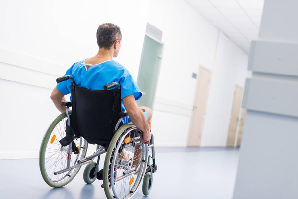 back view of male patient in wheelchair in hospital - Zdjęcie, obraz