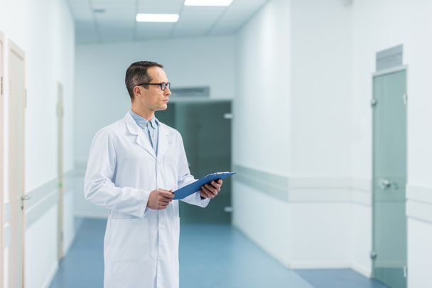 médecin masculin en manteau blanc exploitation diagnostic à l'hôpital
  - Photo, image