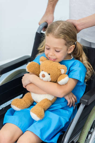little child with teddy bear sitting in wheelchair in hospital - Фото, зображення