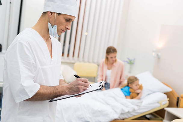 doctor writing something to clipboard in hospital - Photo, image