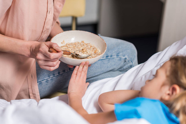 cropped image of sick kid rejecting food from mother - Photo, Image