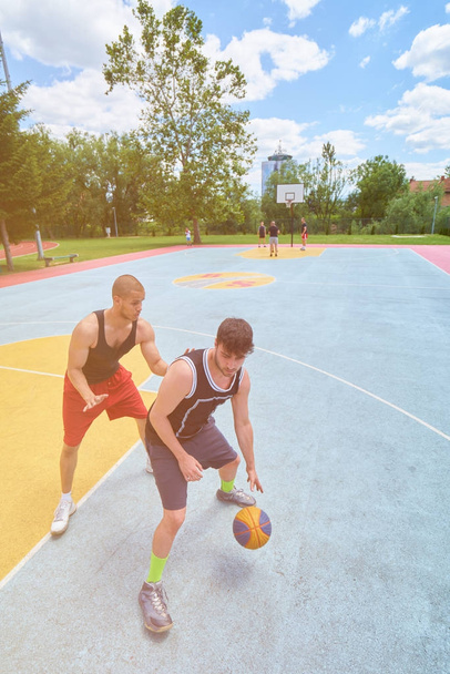 Couple of guys playing basketball outside      - Valokuva, kuva