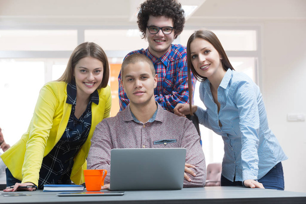 Retrato de un grupo de personas creativas que se reúnen con un ordenador portátil en una oficina moderna. Gente de negocios que tiene una conversación relajada sobre un nuevo proyecto en el espacio de coworking
 - Foto, imagen