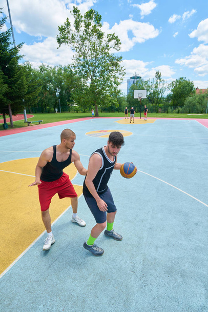 Couple of guys playing basketball outside      - Foto, Imagen