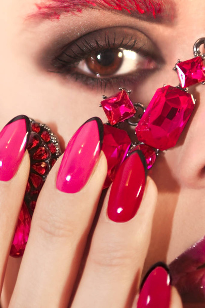 Young beautiful girl with red rose make-up and manicure closeup. - Foto, afbeelding