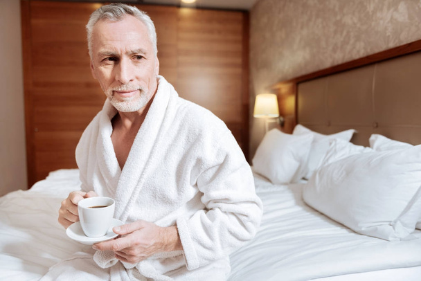 Senior pleasant man sitting with coffee - Фото, зображення