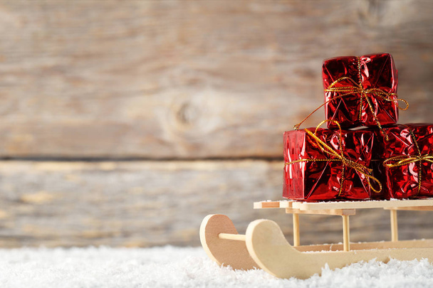 Puinen lelu reki punaisella lahjapakkauksella
  - Valokuva, kuva