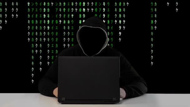 Erkek hacker bir bilgisayar vs yeşil matris kod arka plan üzerinde çalışma - Video, Çekim