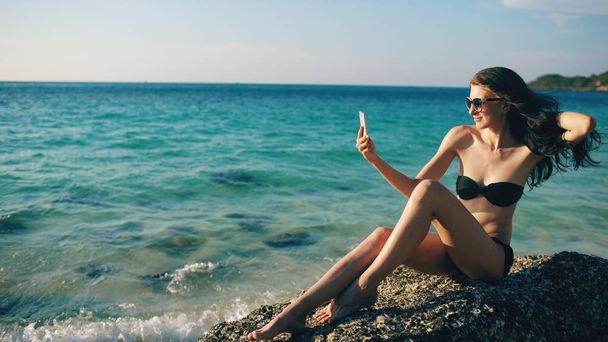 schöne Frau macht Selfie mit Handy am Strand lächelnd und genießt Reisen Lebensstil im Urlaub - Foto, Bild
