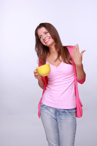 Young womanholding yellow tea cup - Foto, immagini