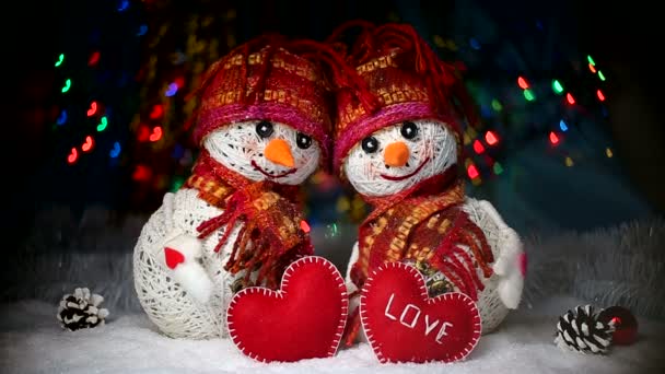 Valentinstag. Liebhaber von Schneemännern sind im Schnee und halten die Herzen des Stoffes - Filmmaterial, Video