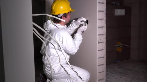 Elektriker montieren Lichtschalter-Steckdose. Arbeiter mit Helm und Arbeitskleidung - Filmmaterial, Video