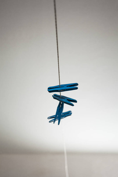 Clothespin on a wire. Blue plastic pincers. - Foto, imagen
