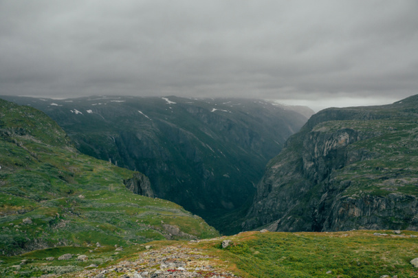 a sziklák alatt ködös időjárás, Norvégia, Hardangervidda Nemzeti Park füves lejtők - Fotó, kép
