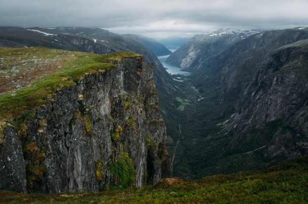 sziklák és füves cliff, hegyi folyó a háttérben, Norvégia, Hardangervidda Nemzeti Park - Fotó, kép