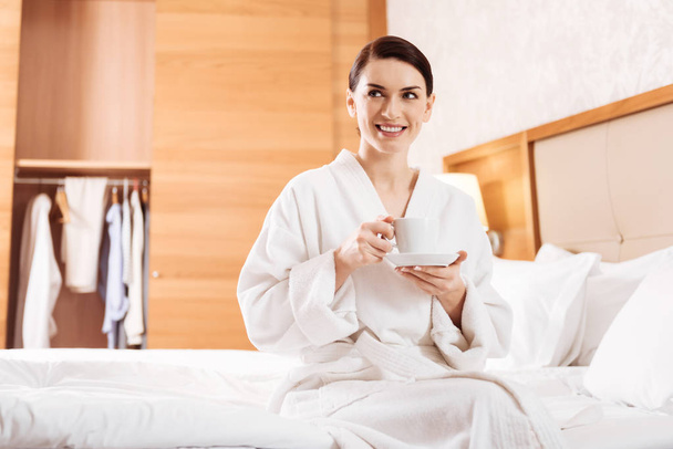 Cool relaxed woman sitting on the bed - 写真・画像