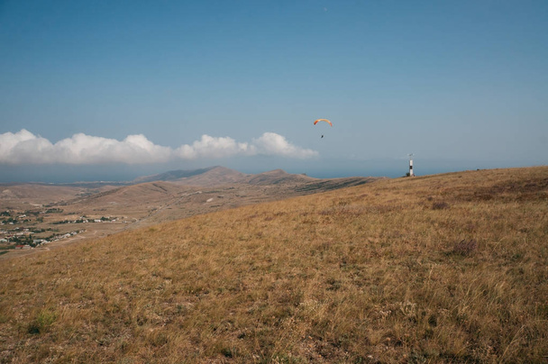 Parachute in de hemel over veld op gebied van de heuvel van de Krim, Oekraïne, mei 2013 - Foto, afbeelding