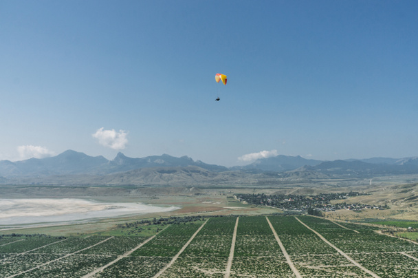Mountainous landscape with paratrooper flying in the sky, Crimea, Ukraine, May 2013 - Photo, Image