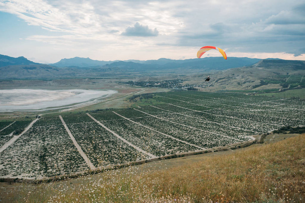 Parachute in the sky over field in hillside area of Crimea, Ukraine, May 2013 - Photo, Image