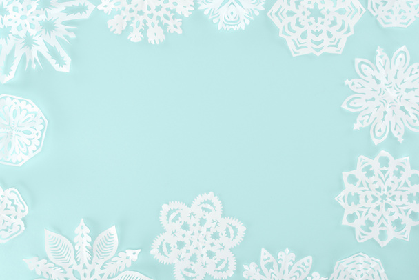明るい青に分離された装飾的な雪の結晶のクリスマス フレーム - 写真・画像
